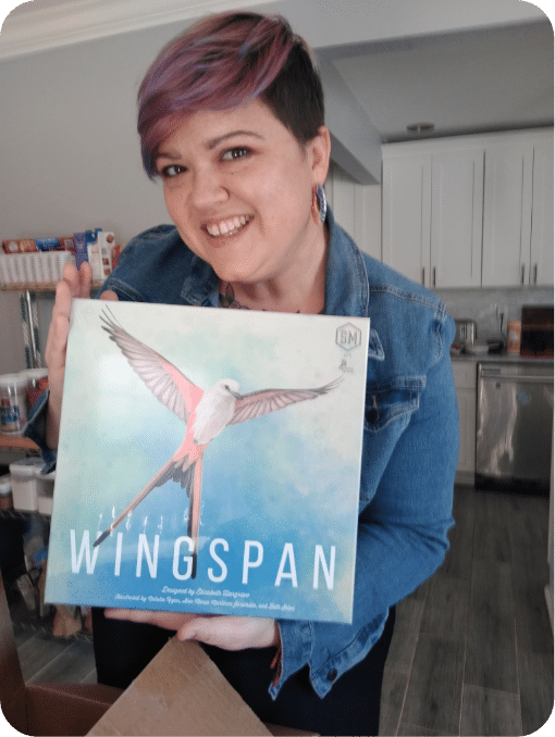woman holding box of wingspan board game